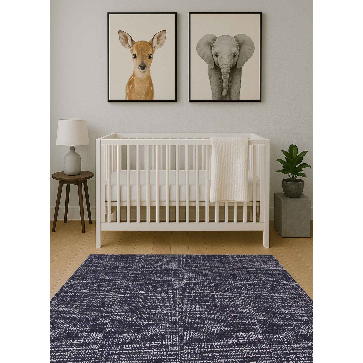 Swankymat navy speckled exercise mat and play mat in baby nursery with white crib, animal art, and wood floor.
