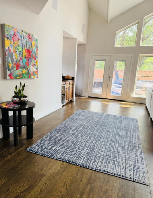 Sloane Midnight Swankymat, a non-toxic high-density foam exercise mat in a deep midnight-blue crosshatch, styled like an area rug in a living room