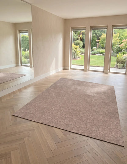 Flora Blush extra-large exercise mat styled on a herringbone wood floor in a bright, window-lit room, blush floral on non-toxic foam