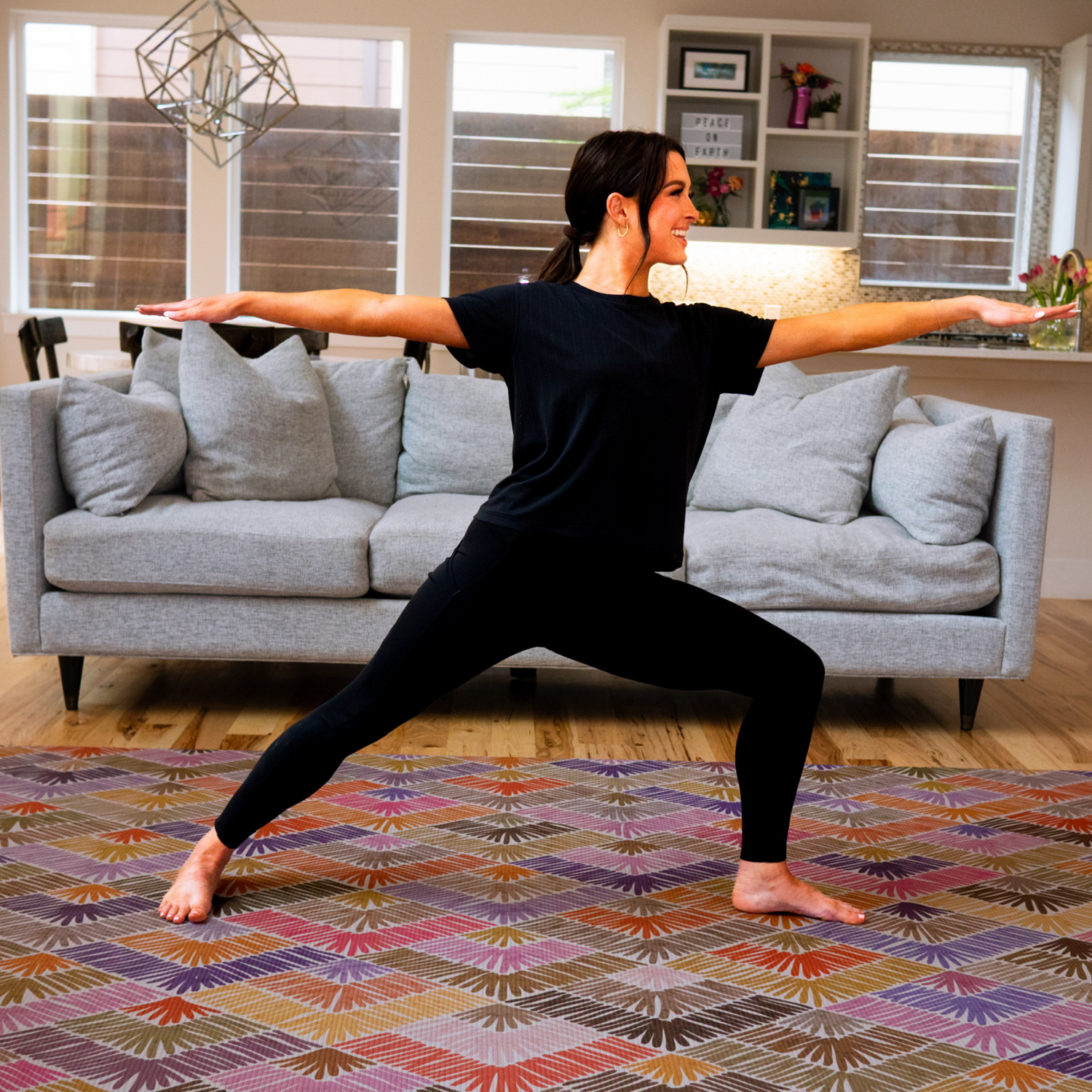 Woman doing fitness stretch on stylish pink decorative exercise mat for decor