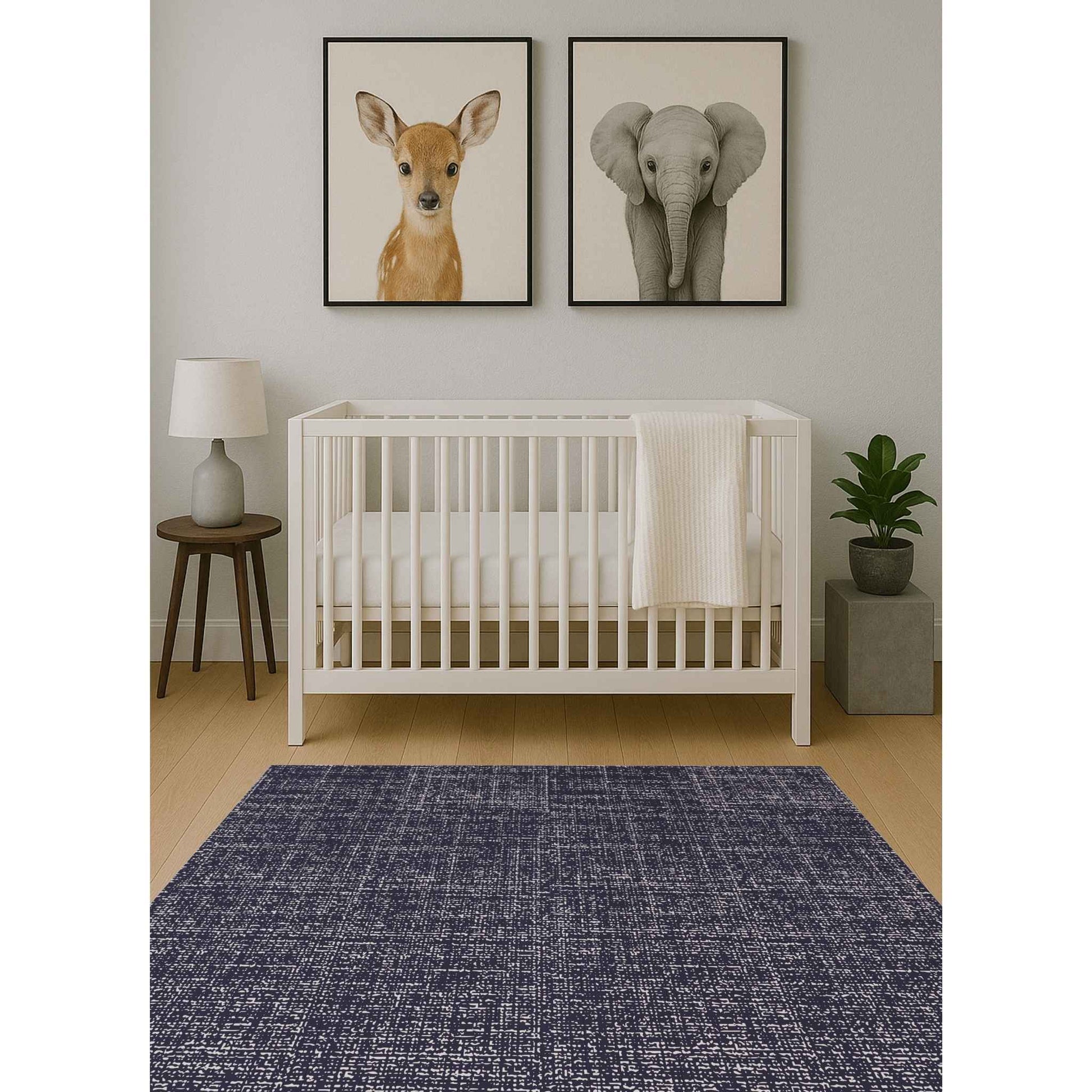 Swankymat navy speckled exercise mat and play mat in baby nursery with white crib, animal art, and wood floor.