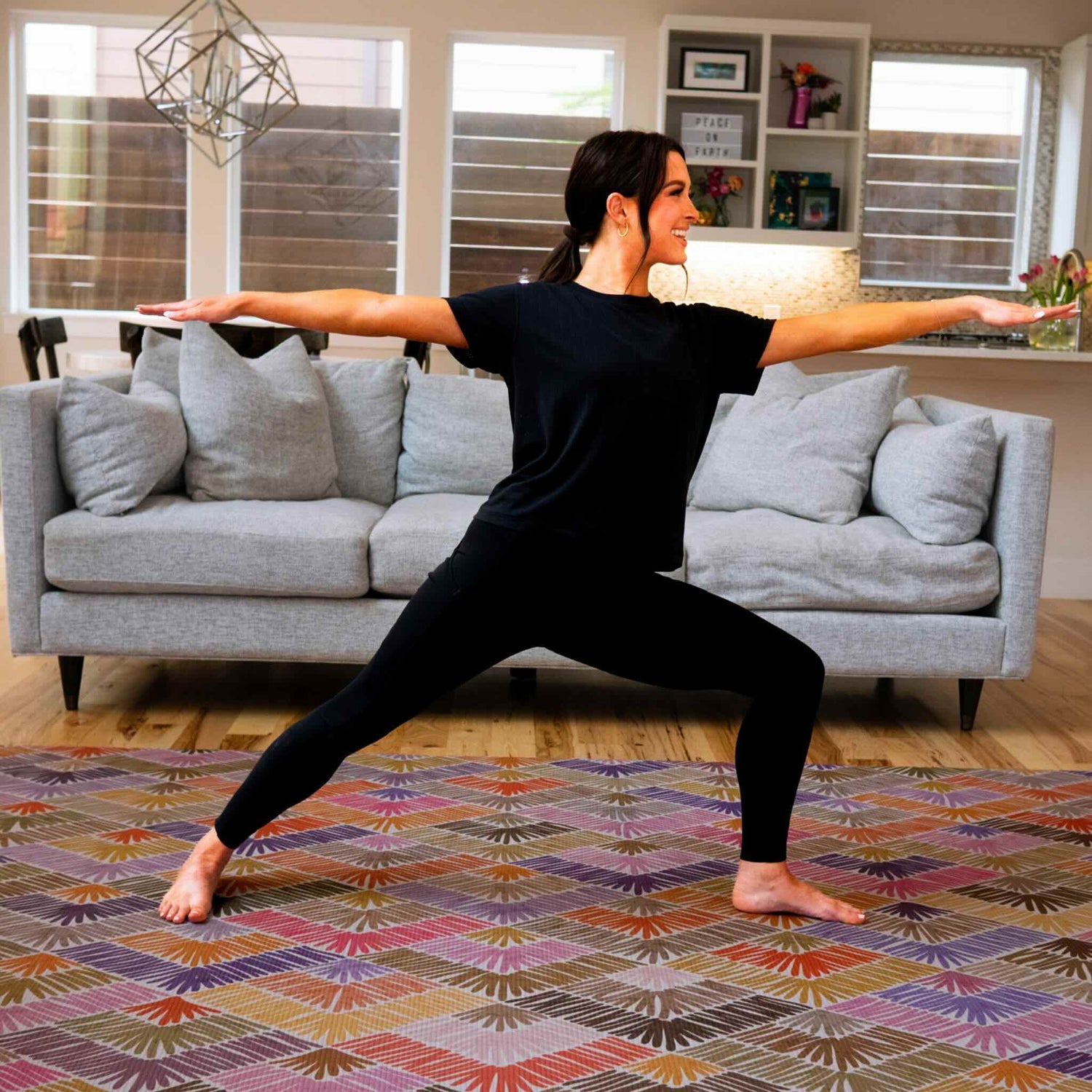 Woman exercising on pink yoga mat in stylish living room styled with neutral and pink colors