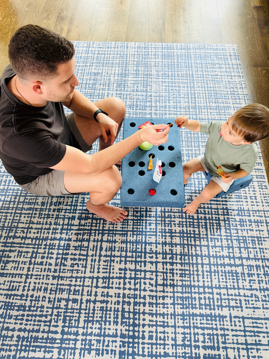 Father and toddler playing on Sloane Navy exercise mat and play mat with blue geometric design