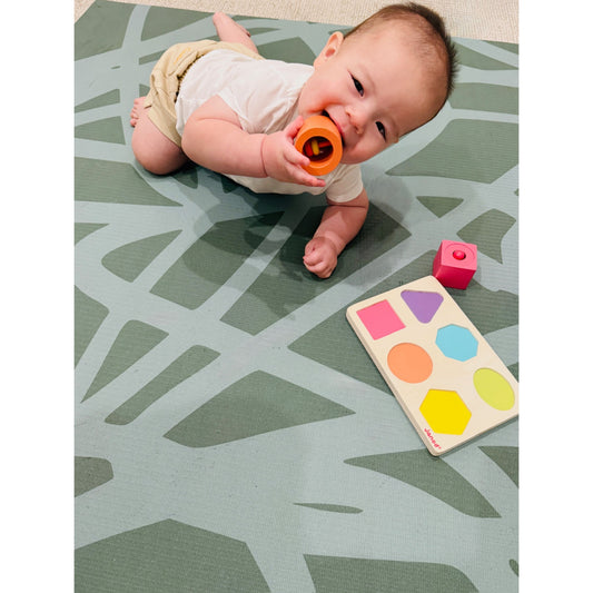 Baby playing on Swankymat non-toxic eco-friendly extra large exercise mat and play mat in Scribble Forest design with toys
